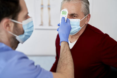 Midsection of doctor holding dentures