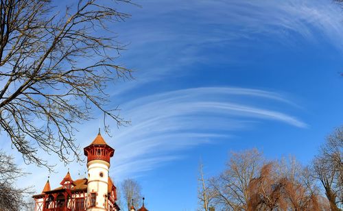 Low angle view of trees and building against sky