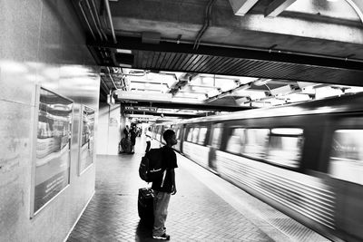 Rear view of people waiting at railroad station