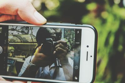 Close-up of woman photographing through smart phone