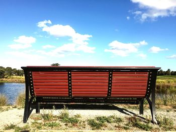 Scenic view of bench against cloudy sky