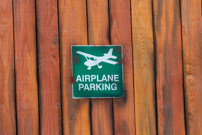 Close-up of warning sign on wooden plank