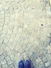 Low section of person standing on tiled floor