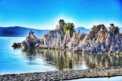 Panoramic view of rocks in sea against clear blue sky