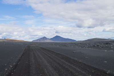 Road amidst desert against sky