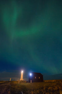 Scenic view of illuminated field against sky at night