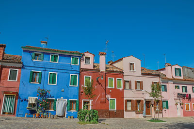 View of colorful houses on sunny day in burano, a gracious little town full of canals in italy.