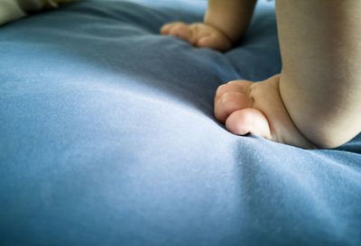 Low section of baby feet on bed