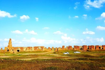 View of old ruin on field against sky