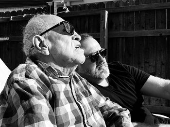 Men wearing sunglasses looking away at backyard