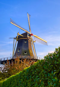 Traditional windmill on field against sky