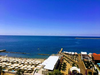 High angle view of buildings by sea against clear sky