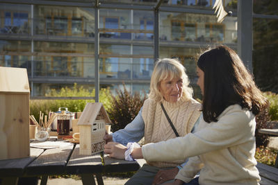 Woman and girl making bug hotels together