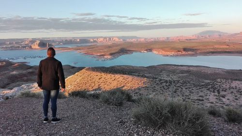 Full length rear view of man standing against lake powell