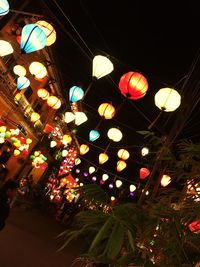 Low angle view of illuminated lanterns hanging at night