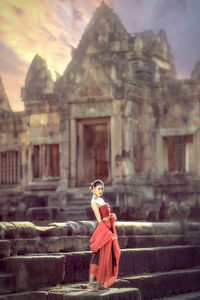 Woman standing by historic building