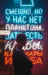 Rear view of woman standing against illuminated sign