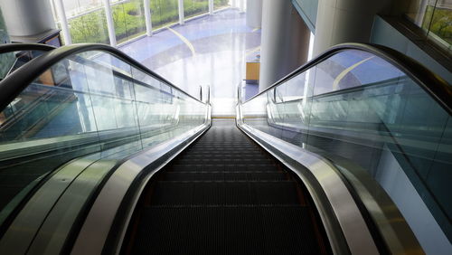 View of narrow escalator along glass railings