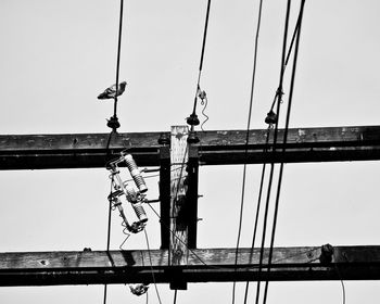 Low angle view of power lines against clear sky