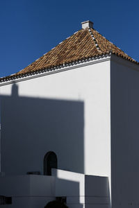 Low angle view of building roof against clear sky