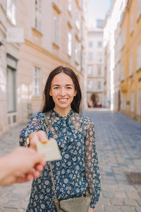 Portrait of young woman standing in city