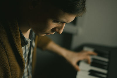 Side view of baby boy playing piano