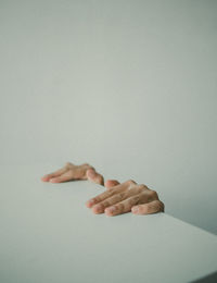 Close-up of hand against wall