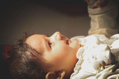 Close-up portrait of cute baby sleeping on bed at home
