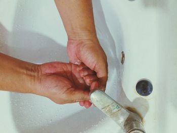 Close-up of man holding hands at home