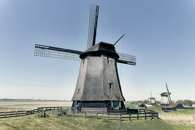 Traditional windmill on field against sky