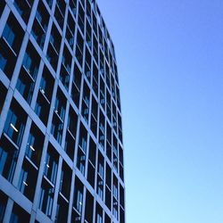 Low angle view of buildings against clear blue sky