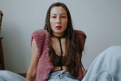 Sad woman with pink makeup at home