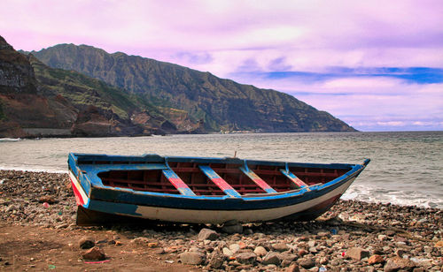 Boat moored on shore against sky