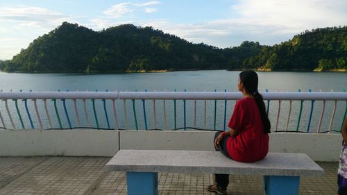 Woman sitting on bench at observation point