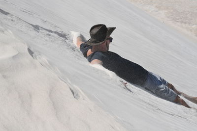 High angle view of man sliding on sand dune