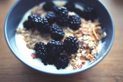 Close-up of blackberries on granola in bowl at table