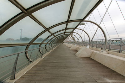 Footbridge over footpath against sky