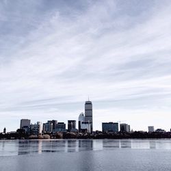 Frozen river against modern buildings during winter