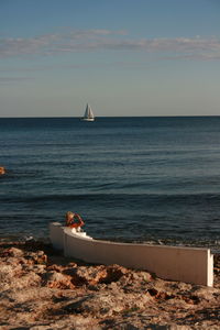 Boat sailing on sea against sky