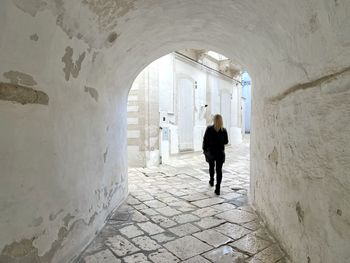 Rear view of man walking in tunnel