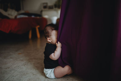 Cute boy sitting on floor at home