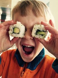 Close-up of happy boy holding sushi