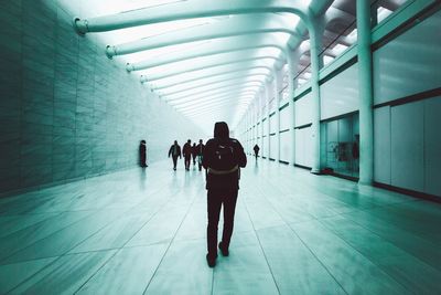 Rear view of man walking in underground walkway