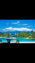 Swimming pool by sea against sky