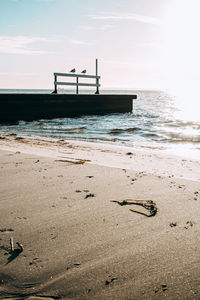 Lifeguard hut on beach against sky