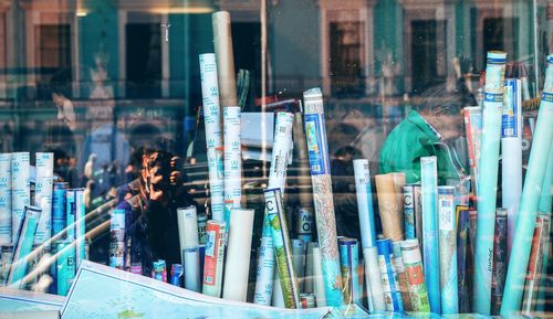 Map rolls in store seen through glass window