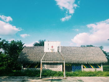 Houses by trees against blue sky