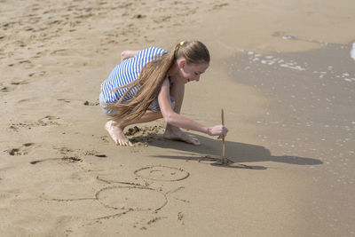 Full length of playful girl on shore at beach