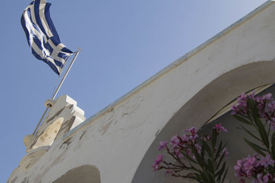 Low angle view of cross against building against clear blue sky