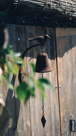 Bell hanging on wooden post